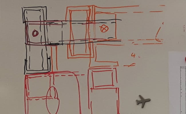 Håndtegnet skitse af bygningsplan på whiteboard
