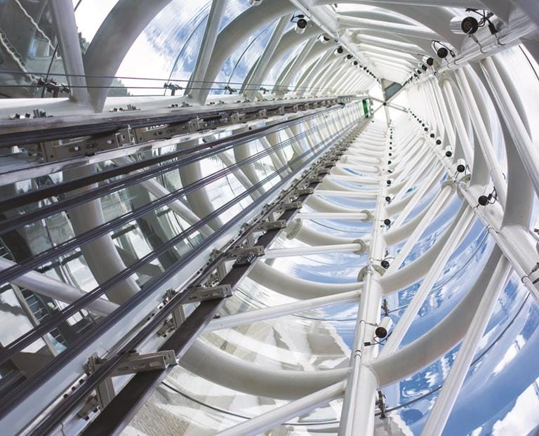 Moderne glaselevator i futuristisk bygning med stålkonstruktion