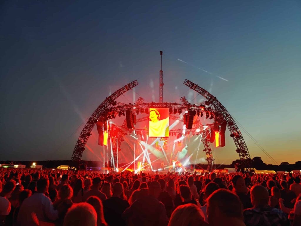 Publikum nyder koncert ved solnedgang på udendørs scene