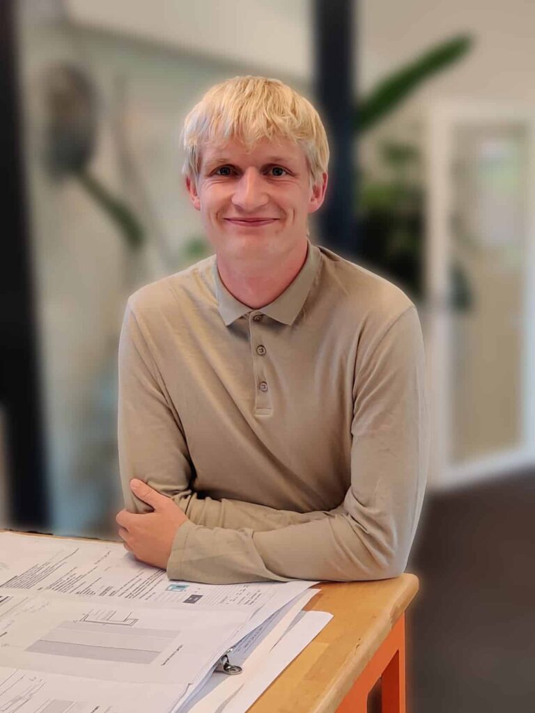Person sidder ved skrivebord med dokumenter